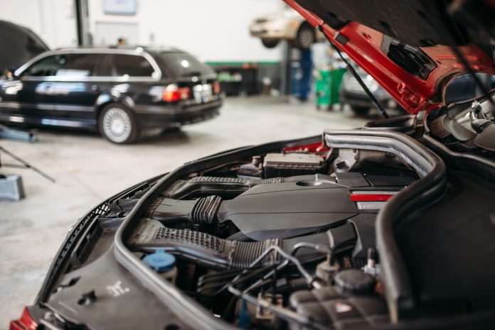 Car with opened hood in automobile service
